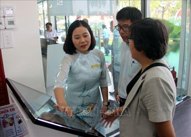 Các đại biểu cùng mọi người đọc sách, tìm kiếm tài liệu trong ngày khai trương Thư viện số cộng đồng Tam Kỳ. Ảnh: Trịnh Bang Nhiệm - TTXVN