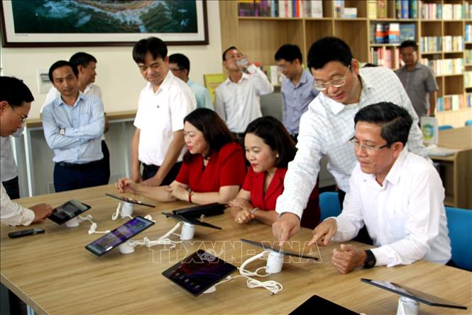 Các đại biểu cùng mọi người đọc sách, tìm kiếm tài liệu trong ngày khai trương Thư viện số cộng đồng Tam Kỳ. Ảnh: Trịnh Bang Nhiệm - TTXVN