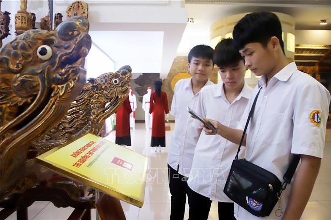 Trong ảnh: Các em học sinh quét mã QR để tìm hiểu về các hiện vật đang được trưng bày tại Bảo tảng Hùng Vương thông qua ứng dụng thuyết minh tự động. Ảnh: Trung Kiên - TTXVN