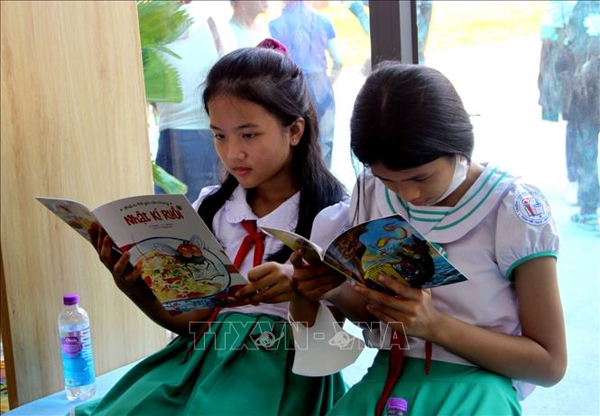 Các đại biểu cùng mọi người đọc sách, tìm kiếm tài liệu trong ngày khai trương Thư viện số cộng đồng Tam Kỳ. Ảnh: Trịnh Bang Nhiệm - TTXVN