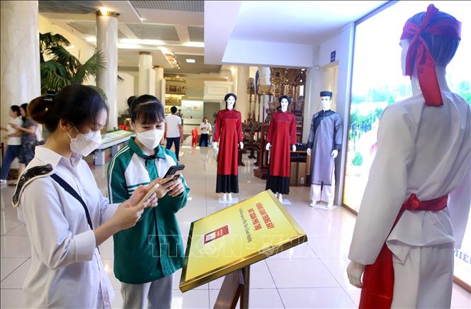 Trong ảnh: Các em học sinh quét mã QR để tìm hiểu về Hát Xoan tại Bảo tảng Hùng Vương thông qua ứng dụng thuyết minh tự động. Ảnh: Trung Kiên - TTXVN