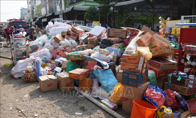 Phát hiện vụ cháy, một số hàng hóa nhanh chóng được mang ra ngoài, hạn chế thiệt hại. Ảnh: Nhựt An - TTXVN