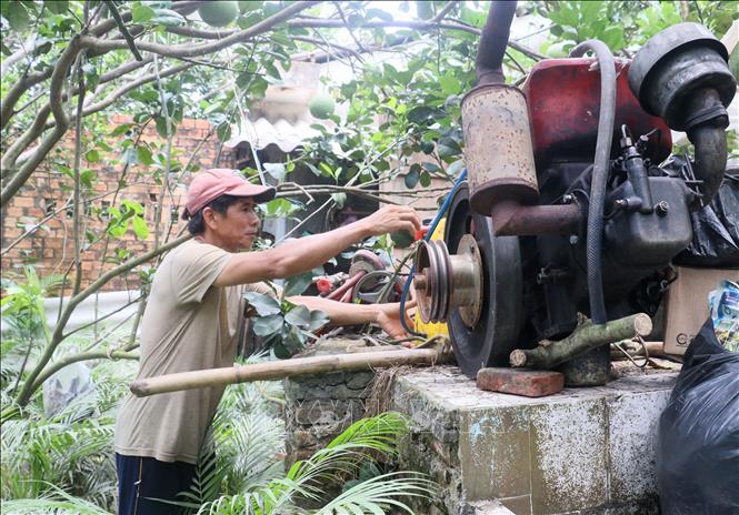 Ông  Nguyễn Chí Lập, xã Quới Thiện, huyện Vũng Liêm, tỉnh Vĩnh Long dời các máy móc lên cao để không bị ngập nước. Lê Thúy Hằng - TTXVN