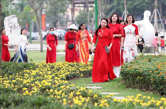 Phụ nữ Đất Tổ háo hức di chuyển đến nơi tổ chức sự kiện có số người mặc áo dài đông nhất. Ảnh: Trung Kiên - TTXVN