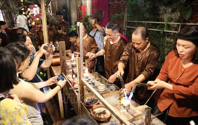 Các nghệ nhân trình diễn chế tác sản phẩm kim hoàn. Ảnh: Thanh Tùng - TTXVN
