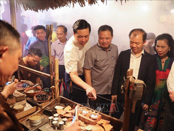 Đại biểu tham quan, tìm hiểu về chế tác sản phẩm kim hoàn. Ảnh: Thanh Tùng - TTXVN