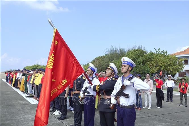 The delegation join soldiers in a national flag saluting ceremony on Truong Sa island. VNA Photo: Thu Phương