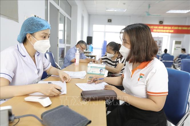 Người dân đến đăng ký tiêm vaccine phòng COVID-19 tại điểm tiêm quận Hai Bà Trưng. Ảnh: Minh Quyết - TTXVN