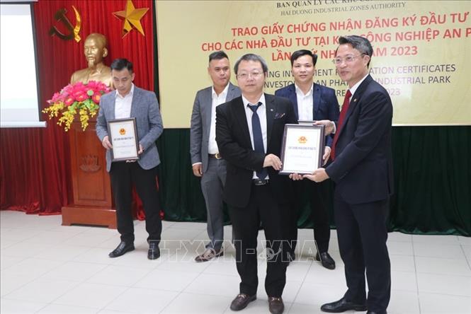 Ông Nguyễn Trung Kiên, Trưởng Ban Quản lý các Khu công nghiệp tỉnh Hải Dương trao giấy chứng nhận đăng ký đầu tư cho 4 nhà đầu tư. Ảnh: Mạnh Minh - TTXVN