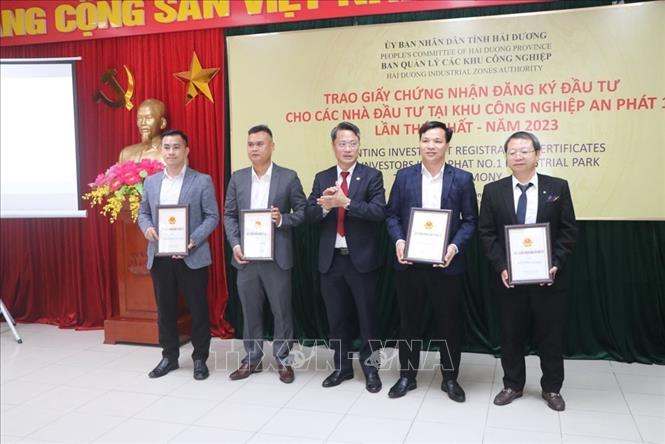 Ông Nguyễn Trung Kiên, Trưởng Ban Quản lý các Khu công nghiệp tỉnh Hải Dương trao giấy chứng nhận đăng ký đầu tư cho 4 nhà đầu tư. Ảnh: Mạnh Minh- TTXVN