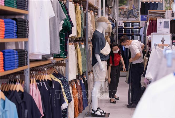 Khách hàng chọn mua sản phẩm tại cửa hàng Uniqlo - Vincom Bà Triệu. Ảnh: Hoàng Hiếu - TTXVN