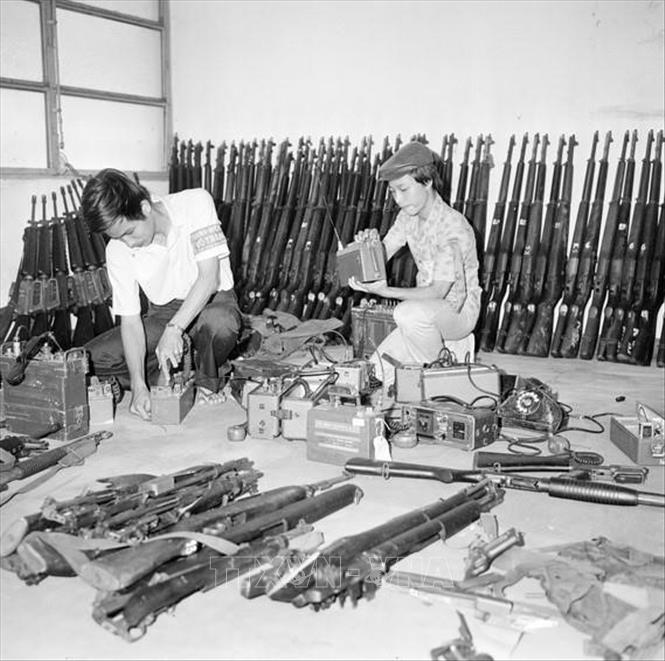 Tự vệ Sài Gòn thu dọn vũ khí của quân ngụy bỏ lại khi thua chạy (1975). Ảnh: Đinh Quang Thành – TTXVN