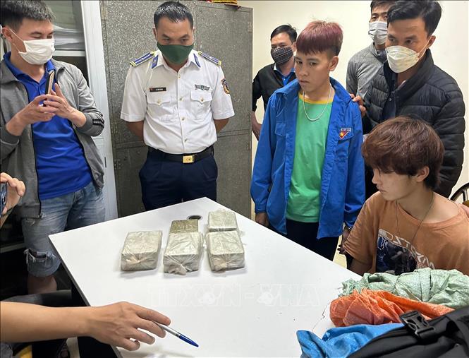 Đối tượng và tang vật của vụ án mua, bán trái phép 9 bánh heroin bị bắt giữ. Ảnh: TTXVN phát
