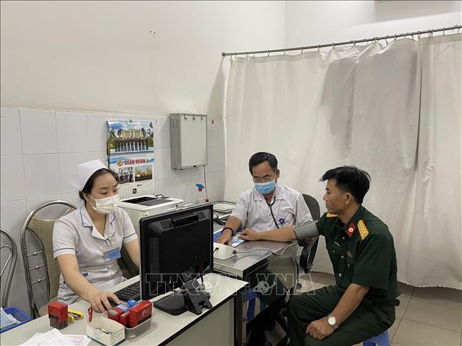 Các nhân viên y tế của Bệnh viện Quân y 4 đang chăm sóc, trả kết quả cho người bệnh. Ảnh: Huyền Trang - TTXVN
