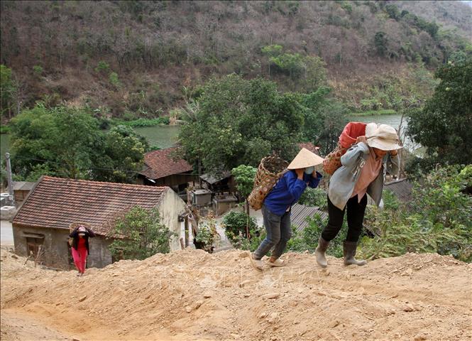 Những bao cát, sỏi nhỏ nặng 20-30kg được các thanh niên trong bản vận chuyển đưa lên đồi để làm nên nhà cho các hộ nghèo ở xã Tà Cạ, huyện Kỳ Sơn, Nghệ An. Ảnh: Văn Tý-TTXVN