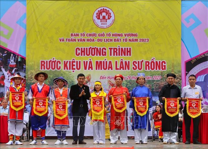 Trao cờ lưu niệm cho đại diện các đoàn tham gia rước kiệu. Ảnh: Tuấn Đức - TTXVN