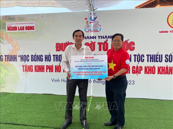 Ông Tô Đình Tuân, Tổng Biên tập Báo Người Lao động trao 100 suất học bổng cho 100 em học sinh có hoàn cảnh khó khăn khu vực biên giới của tỉnh Long An. Ảnh: Đức Hạnh - TTXVN 