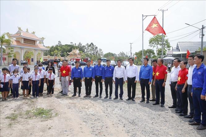 Đại biểu và học sinh chụp hình lưu niệm tại “Đường cờ Tổ quốc” đoạn qua Khu di tích lịch sử quốc gia Đồn Long Khốt trên địa bàn huyện biên giới Vĩnh Hưng, tỉnh Long An. Ảnh: Đức Hạnh - TTXVN 