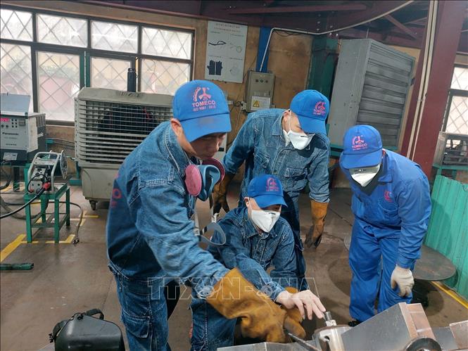Anh Nguyễn An Ngọc, Công ty Cổ phần Tomeco An Khang - “Công nhân giỏi Thủ đô” năm 2023 cùng đồng nghiệp nghiên cứu sản phẩm để hàn chính xác. Ảnh: TTXVN phát