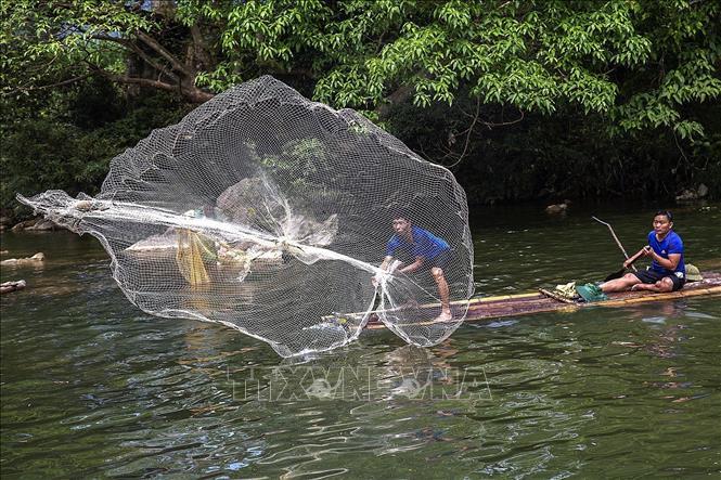 Trong ảnh: Người dân tung lưới bắt cá trong lễ hội. Ảnh: Trọng Đạt - TTXVN
