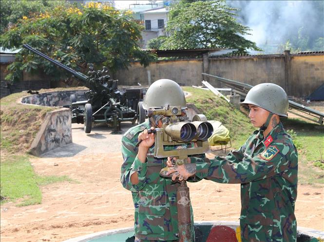 Chiến sĩ Đại đội 8, Tiểu đoàn phòng không 3 sử dụng kính chỉ huy sục sạo mục tiêu của pháo 37mm trong buổi huấn luyện báo động cấp 1, sẵn sàng chiến đấu bảo vệ các mục tiêu trên thành phố mang tên Bác. Ảnh: Trọng Đức - TTXVN
