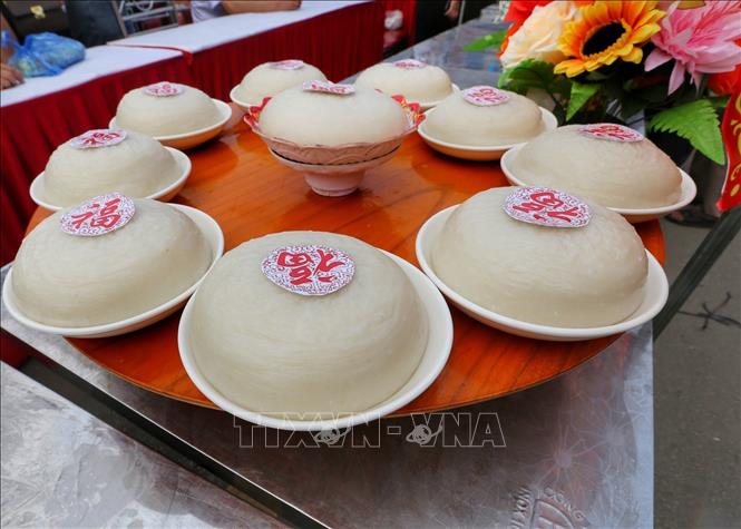 Ở phần thi giã bánh giầy, các đội tranh tài nội dung thổi 5kg gạo nếp thành xôi trong thời gian tối đa 30 phút, giã và bắt thành 10 chiếc bánh giầy trong thời gian tối đa 15 phút. Ảnh: Tuấn Đức - TTXVN