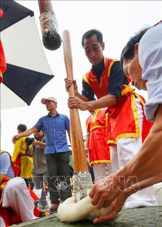 Đội thi huyện Tam Nông trong phần thi giã bánh giầy. Ảnh: Tuấn Đức - TTXVN