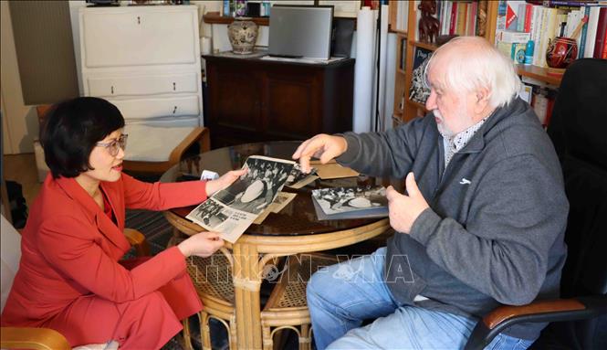 Ông Ralph Coeckelberghs giời thiệu với phóng viên TTXVN tại Bỉ những bài báo nói về nhóm thanh niên đụng độ với cảnh sát khi tham gia cuộc biểu tình chống chiến tranh Việt Nam, tháng 9/1968. Ảnh: Duy Tùng - PV TTXVN tại Bỉ