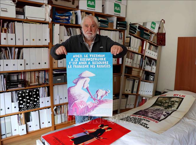 Ông Ralph Coeckelberghs và bức tranh cổ động ủng hộ Việt Nam. Ảnh: Hương Giang - PV TTXVN tại Bỉ