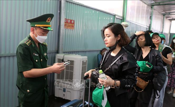 Lực lượng biên phòng Cửa khẩu quốc tế Lào Cai làm thủ tục xuất cảnh cho du khách. Ảnh: Quốc Khánh - TTXVN