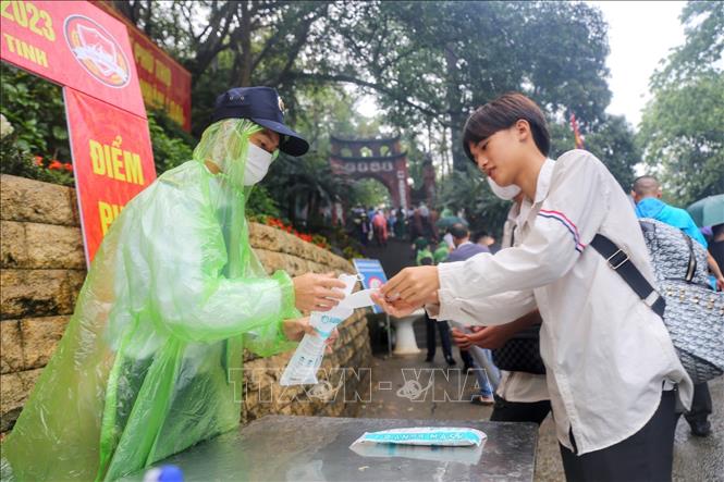 Phát khẩu trang cho những người không đem theo. Ảnh: Tuấn Đức - TTXVN