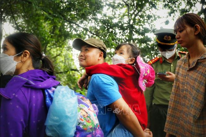 Em nhỏ được bố cõng trên vai. Ảnh: Tuấn Đức - TTXVN