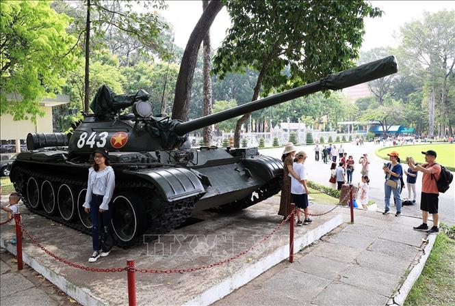 Trong ảnh: Khách du lịch chụp ảnh lưu niệm với phiên bản xe tăng T54B mang số hiệu 843 của Quân đội Nhân dân Việt Nam đã húc đổ cổng phụ của Dinh Độc Lập vào trưa 30/4/1975.Ảnh: Hồng Đạt - TTXVN

