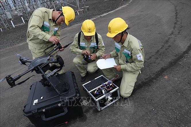 Công nhân Công ty Truyền tải điện 3 (PTC3) sử dụng thiết bị bay không người lái điều khiển từ xa (UAV) kèm thiết bị ghi nhận hình ảnh và camera chuyên dụng để nâng cao hiệu quả quản lý, vận hành lưới điện tại Truyền tải Điện Lâm Đồng. Ảnh: Ngọc Hà - TTXVN