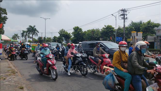 Rất đông các phương tiện giao thông, nhất là xe gắn máy của người dân ở các tỉnh miền Tây như Trà Vinh, Sóc Trăng, Vĩnh Long, Bến Tre,... di chuyển trên Quốc lộ 60 hướng về cầu Rạch Miễu trong chiều 1/5. Ảnh: Chương Đài - TTXVN...