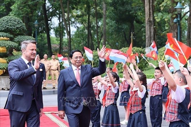 
Thủ tướng Phạm Minh Chính và Thủ tướng Đại Công quốc Luxembourg Xavier Bettel với thiếu nhi Thủ đô tại lễ đón. Ảnh: Dương Giang-TTXVN
