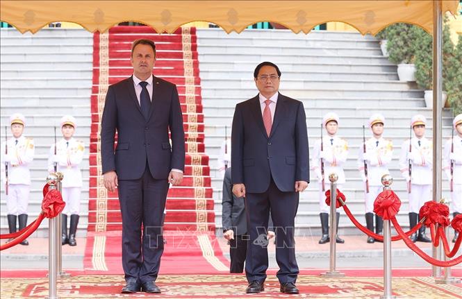Thủ tướng Phạm Minh Chính và Thủ tướng Đại Công quốc Luxembourg Xavier Bettel nghe quân nhạc cử Quốc thiều hai nước. Ảnh: Dương Giang-TTXVN
