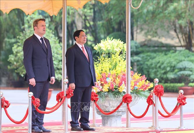 Thủ tướng Phạm Minh Chính và Thủ tướng Đại Công quốc Luxembourg Xavier Bettel nghe quân nhạc cử Quốc thiều hai nước. Ảnh: Dương Giang-TTXVN
