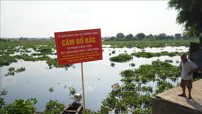 UBND xã Trường Đông đã cấm biển cấm đổ rác thải nhằm hạn chế nước sông Vàm Cỏ Đông ô nhiễm nặng hơn. Ảnh: Thanh Tân - TTXVN