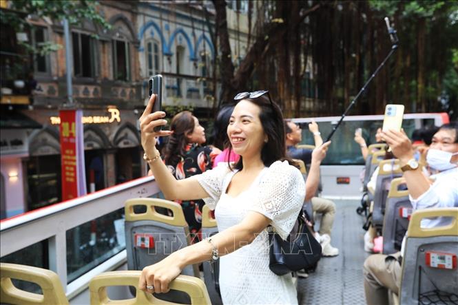 A tourist enjoys the double-decker bus tour. VNA Photo: Tuấn Anh