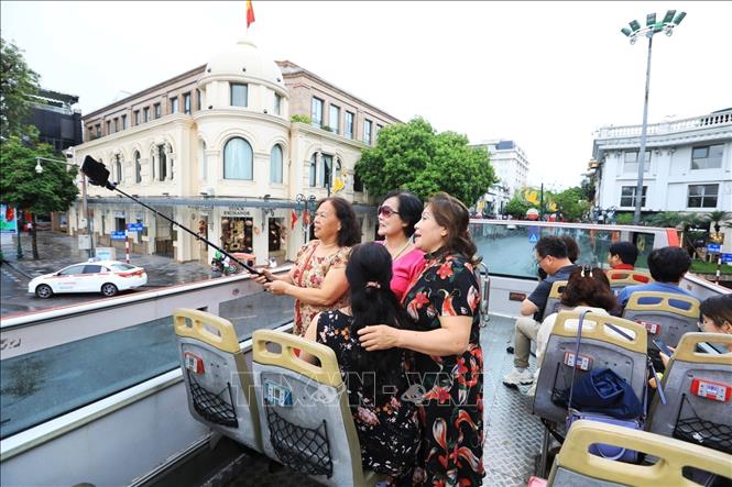 Tourists enjoy double-decker bus tour. VNA Photo: Tuấn Anh