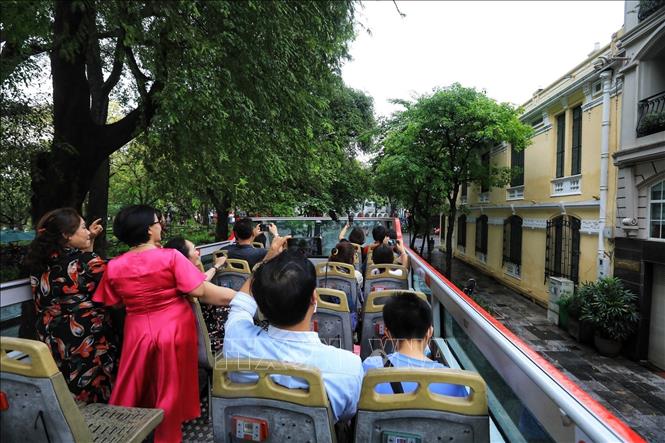 Visitors enjoy the double-decker bus tour. VNA Photo: Tuấn Anh