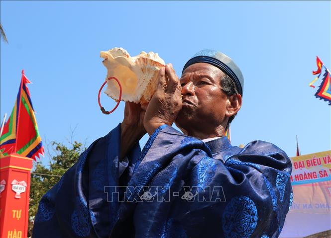 Thổi ốc u khi đưa các hình nhân thế mạng ra biển. Ảnh: Phạm Cường-TTXVN