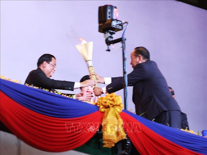 Thủ tướng Campuchia Samdech Techo Hun Sen trao ngọn đuốc Đại hội cho Phó Thủ tướng Campuchia Samdech Tea Banh - Chủ tịch Uỷ ban Tổ chức SEA Games 32. Ảnh: Hoàng Linh-TTXVN 