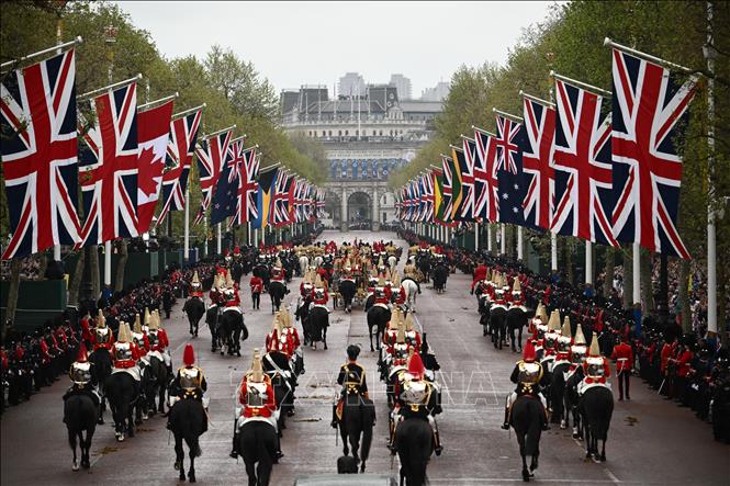 Nhà Vua Anh Charles III cùng Hoàng hậu Camilla ngồi trên cỗ xe ngựa đặc biệt Diamond Jubilee, di chuyển từ Cung điện Buckingham qua đường phố London đến Tu viện Westminster, ngày 6/5/2023. Ảnh: AFP/TTXVN