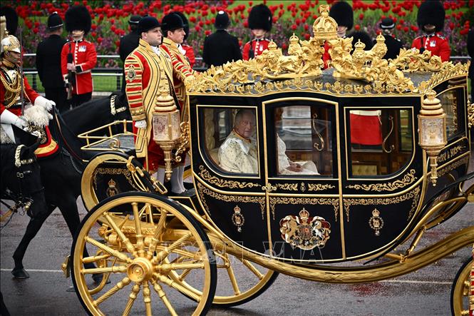 Nhà Vua Anh Charles III cùng Hoàng hậu Camilla ngồi trên cỗ xe ngựa đặc biệt Diamond Jubilee, di chuyển từ Cung điện Buckingham qua đường phố London đến Tu viện Westminster, ngày 6/5/2023. Ảnh: AFP/TTXVN