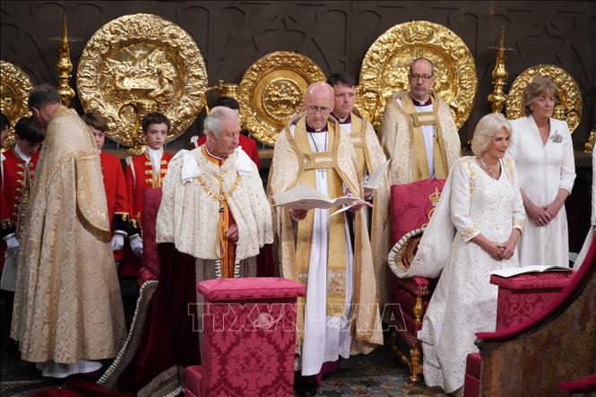 Trong ảnh: Nhà Vua Anh Charles III cùng Hoàng hậu Camilla thực hiện nghi lễ đăng quang tại Tu viện Westminster, ngày 6/5/2023. Ảnh: AFP/TTXVN