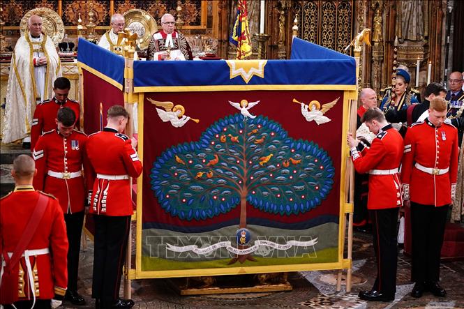 Vua Charles III được xức dầu thánh sau tấm bình phong trong lễ đăng quang tại Tu viện Westminster ở London, Anh ngày 6/5/2023. Ảnh: AFP/TTXVN
