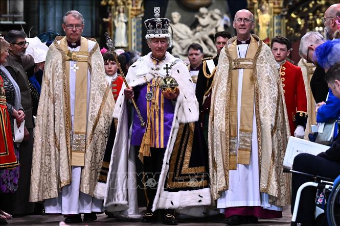 Trong nghi thức cuối cùng của lễ đăng quang, Vua Charles III đội Vương miện Nhà nước Hoàng gia, cầm quả cầu quốc chủ và Trượng Quốc chủ Thập tự, rời Tu viện Westminster, trở về Cung điện Buckingham ở London, Anh ngày 6/5/2023. Ảnh: AFP/TTXVN
