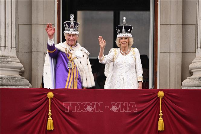 Nhà Vua Anh Charles III, Hoàng hậu Camilla trên ban công Cung điện Buckingham vẫy chào người dân sau khi xem màn biểu diễn của không quân Anh mừng lễ đăng quang, ngày 6/5/2023. Ảnh: AFP/TTXVN